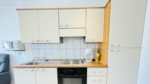 A compact kitchen with a stove, oven, and cabinets. - Jacques Prévert (Bains-les-Bains)