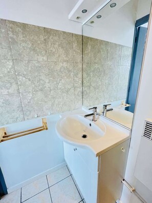 A modern bathroom with a bathtub, a sink, and a mirror.