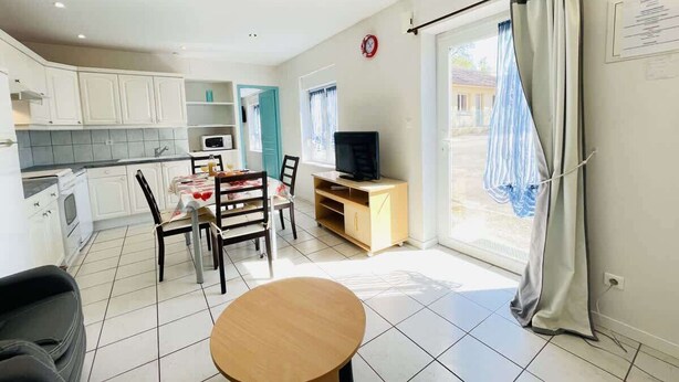 A compact living space with a kitchen, dining area, and a TV. - Louis 11 (Bains-les-Bains)