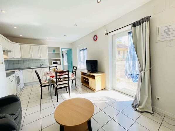 A compact living space with a kitchen, dining area, and a TV.