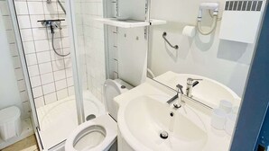 A modern bathroom with a glass-enclosed shower, a toilet, a sink, and a mirror. - Rimbaud (Bains-les-Bains)
