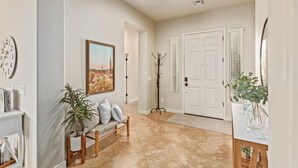 A spacious hallway with a bench, a coat rack, and a door with shutters. - Three Palms at Estrella Mtn Ranch - 3BD with Private heated pool & spa (Goodyear)