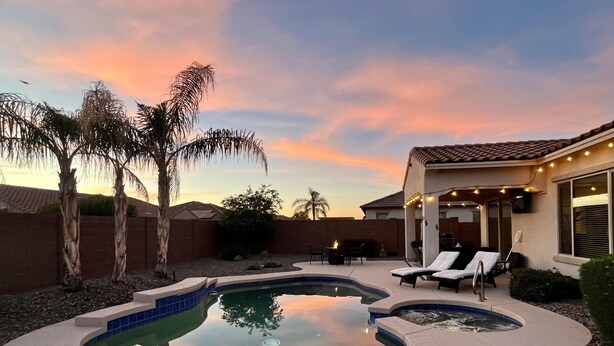 A backyard with a swimming pool, lounge chairs, and a patio area. - Three Palms at Estrella Mtn Ranch - 3BD with Private heated pool & spa (Goodyear)