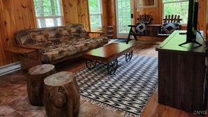Ein Holzinterieur mit einer Couch, einem Couchtisch und einer TV-Konsole.
