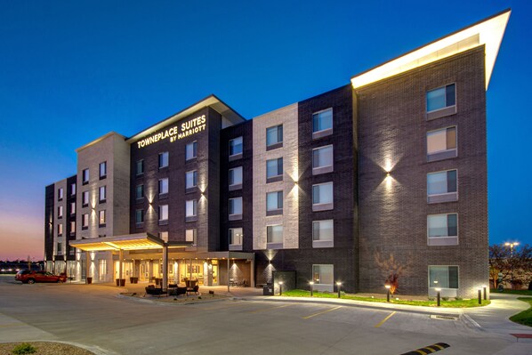 A modern hotel with a brick facade, a well-lit entrance, and a parking area. - TownePlace Suites by Marriott Cincinnati Airport South (Florence)