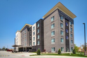 A multi-story hotel with a modern brick facade, large windows, and a clear sky. - TownePlace Suites by Marriott Cincinnati Airport South (Florence)