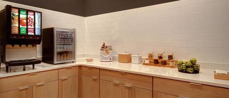 Una cucina con macchina da caffè, frigorifero e diversi oggetti da cucina sul bancone.