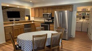 A modern kitchen with wooden cabinets, a stainless steel refrigerator, a microwave, and a dishwasher.