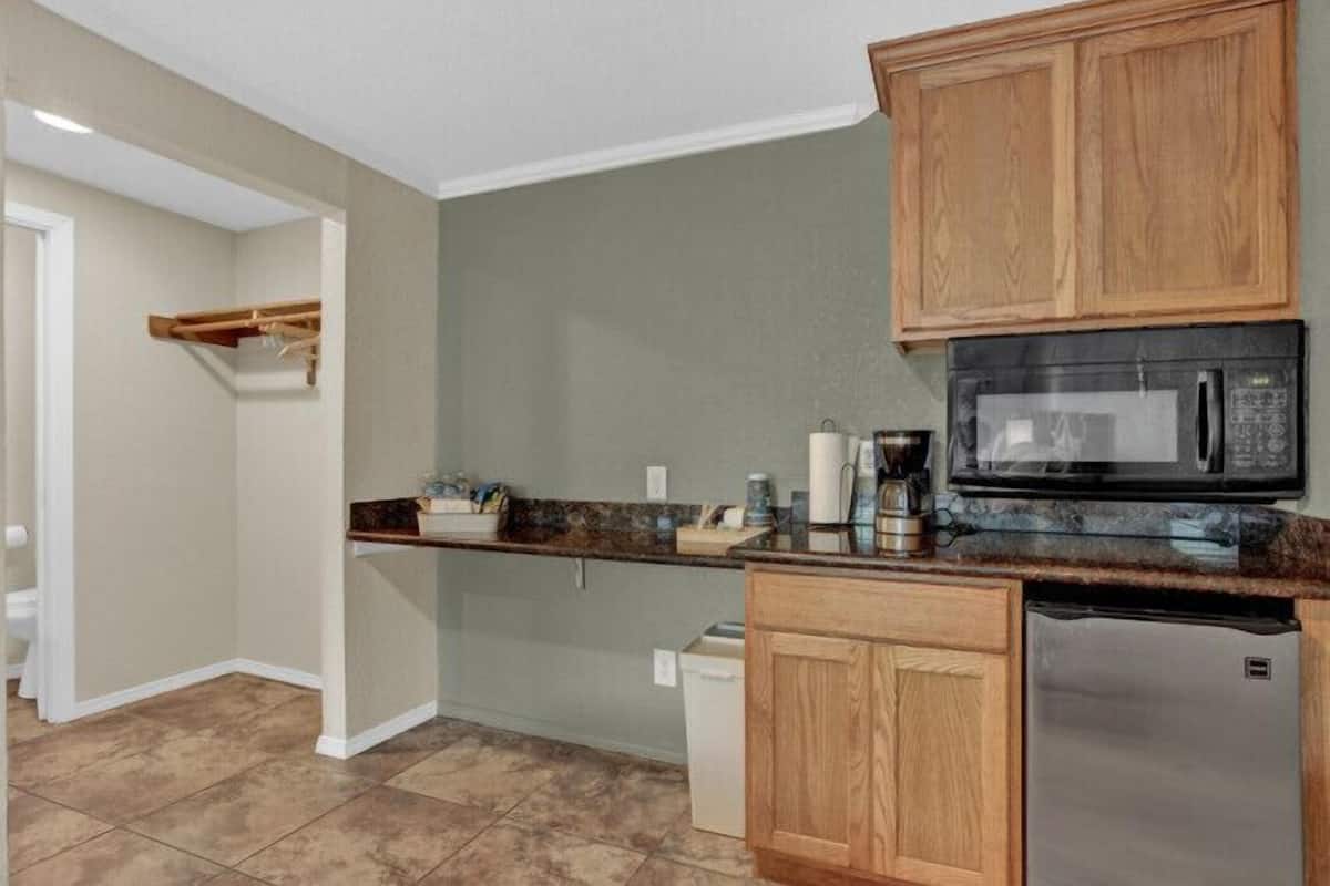 A kitchen with wooden cabinets, a microwave, a coffee maker, and a dishwasher.