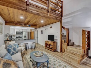 Relax in this inviting living area with a comfortable sofa, coffee table, and staircase leading to an upper level.