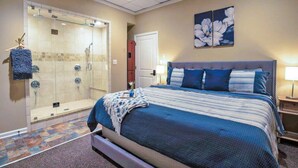 A bedroom with a large bed, a shower area, and a painting on the wall. - Suite in downtown Nashville (Nashville)