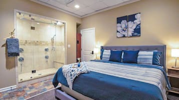 Relax in comfort with a large bed and glass-enclosed shower area.