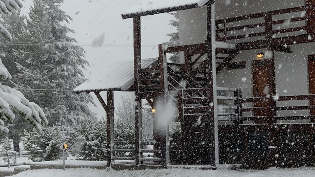 A snow-covered building with a wooden exterior and a covered outdoor area. - Loft Catedral by Base 41 (San Carlos de Bariloche)
