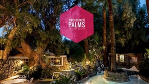 Ein Resort mit Pool, Außenbereich zum Sitzen und einem Schild mit der Aufschrift "Two Bunch Palms Resort & Spa".