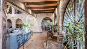 Un interior espacioso con un arco de piedra, un comedor y una sala de estar con sofá y mesa.