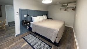 Un dormitorio con cama, mesita de noche, lámpara y ventilador de techo.