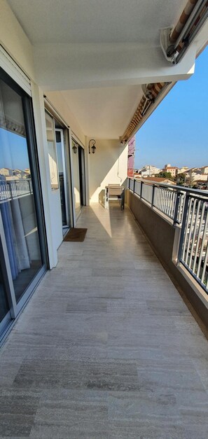Un balcon avec vue sur la ville, une porte-fenêtre coulissante et une petite table.