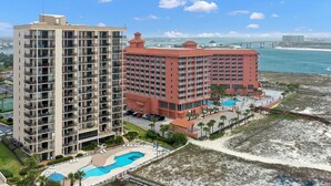 Un hôtel de grande hauteur doté de nombreux balcons, d’une piscine et d’un espace de plage.