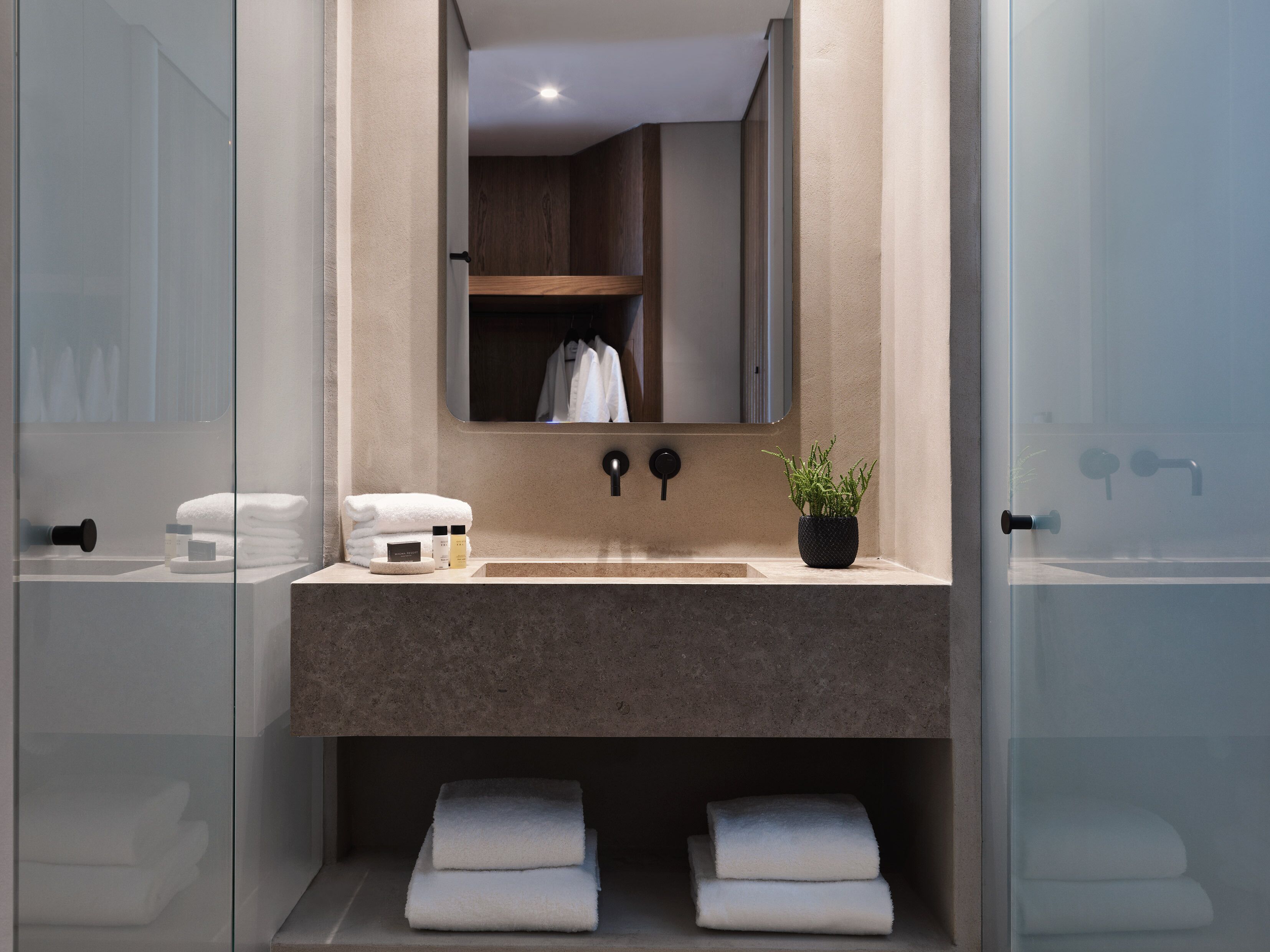 A modern bathroom with a large mirror, a sink, and a towel rack.