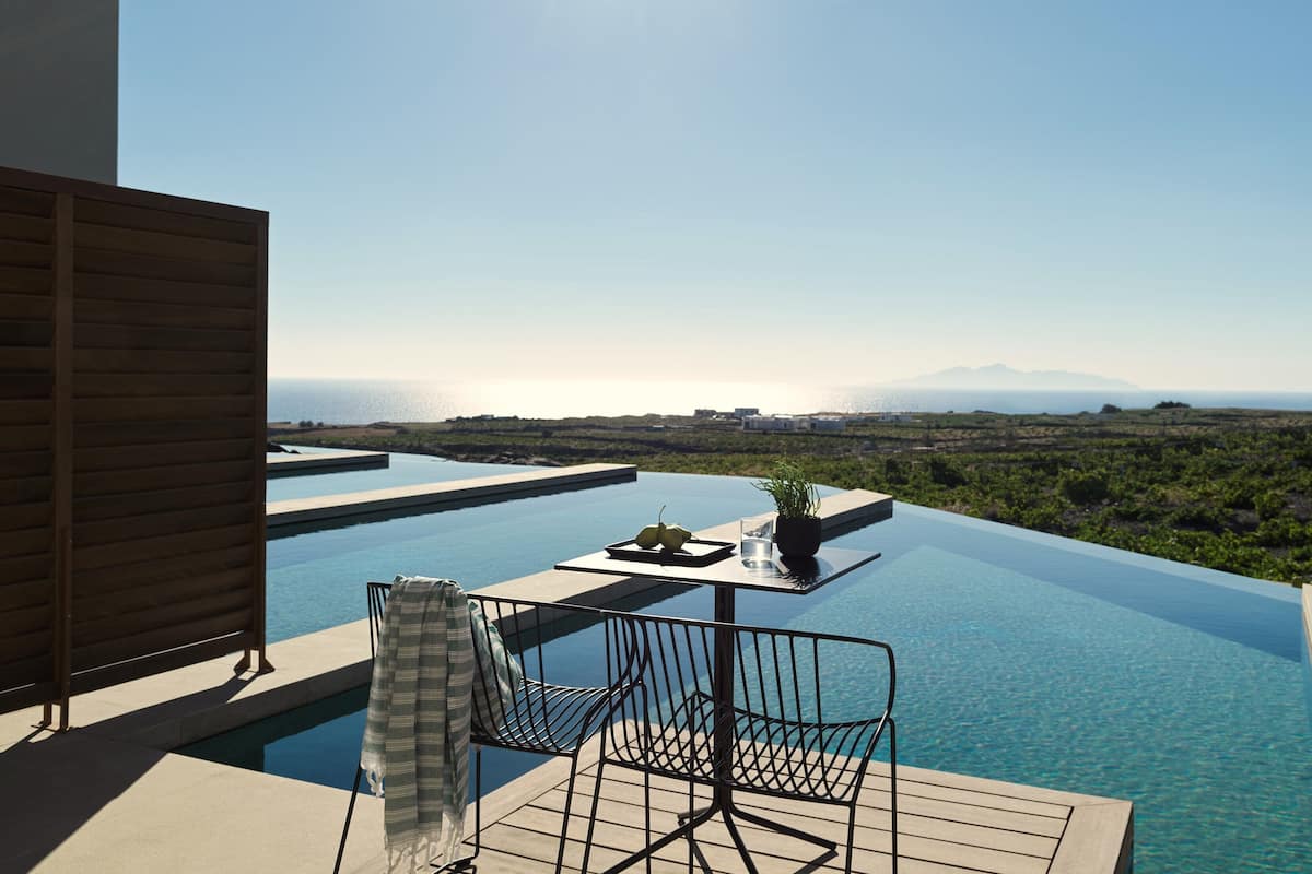 Ein Infinity-Pool auf dem Dach mit Blick auf das Meer und ferne Berge.