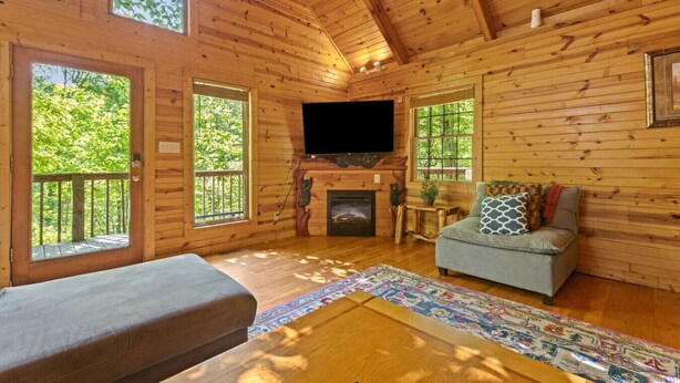 A log cabin with a fireplace, a television, and a sofa. - Beary Secluded- No Pet Fee, Hot Tub, Firepit, WiFi (Slade)