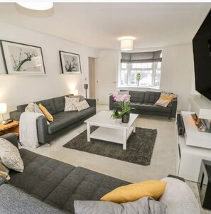 Relax in this stylish living room with a sofa, coffee table, and flat-screen TV.