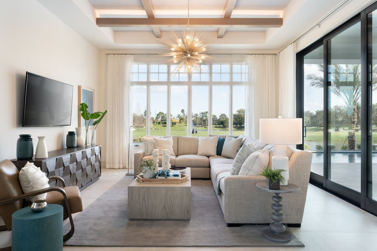 A modern living room with a sectional sofa, a coffee table, and a TV on the wall.