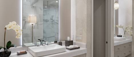 A modern bathroom with a large mirror, two sinks, a towel rack, and a shower area.