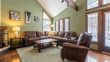 A cozy living room with a sectional sofa, a coffee table, and a fireplace.