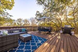 Eine Terrasse mit Gartenmöbeln, einem Grill und einem überdachten Sitzbereich.
