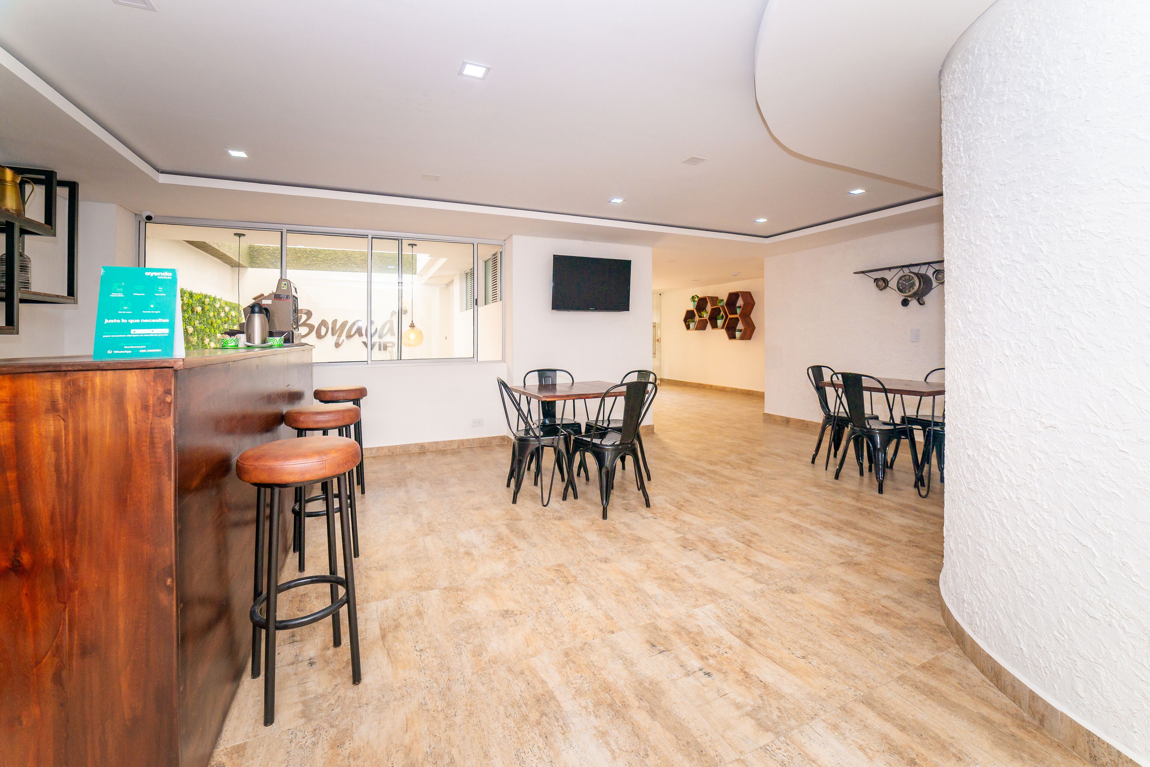 Een moderne bar met houten krukken, een toonbank en een groot raam.