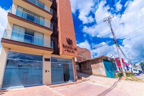Experience the Boyaca Vista Hotel & Spa's striking red brick tower and sleek glass facade, featuring spacious balconies with metal railings.