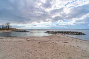 A beach with a rocky breakwater and a clear view of the sea.