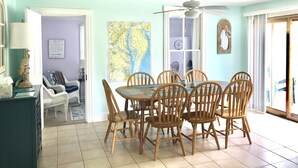 A dining area with a table and chairs, a ceiling fan, and a map on the wall. - Beautiful home & short walk to beach, restaurants, and marinas in Rock Hall, MD (Rock Hall)