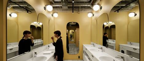 Un baño moderno con dos lavamanos, espejos amplios e iluminación en el techo.