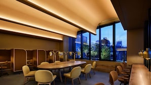 A modern conference room with a large oval table, multiple chairs, and a view of the cityscape through large windows. - 9h nine hours woman Shinjuku (Tokyo)