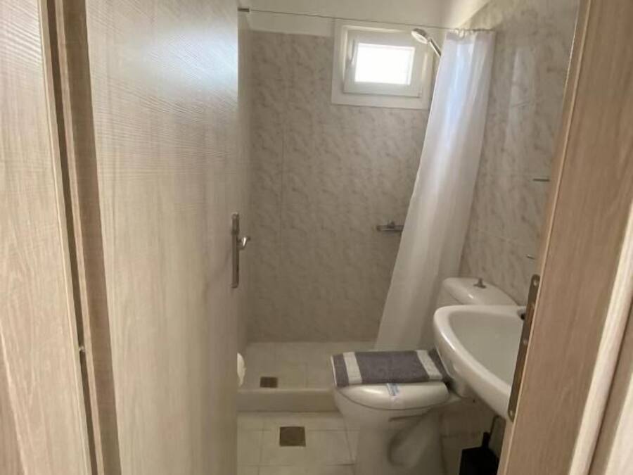 A compact bathroom with a shower, toilet, and sink.