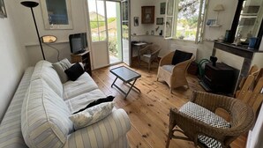 Un salon chaleureux avec un canapé, des fauteuils, une table basse et une cheminée.