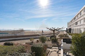 A coastal hotel with a view of the beach, a swimming pool, and a unique tree sculpture. - AS21518-P3 directly beach with sea view and pool (LE GRAU DU ROI)