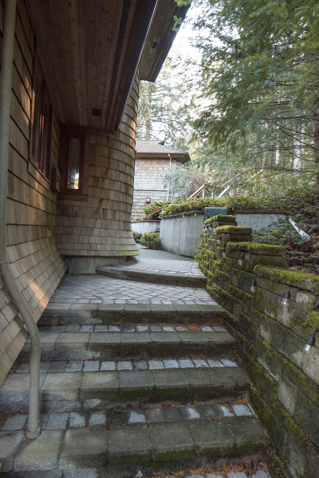 A stone staircase leading to a wooden building with a sloped roof.