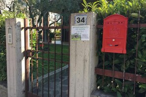 Une entrée fermée par un portail, avec une boîte aux lettres et un panneau indiquant qu’un appartement à louer, appelé Casa Mary, se trouve à cet endroit.