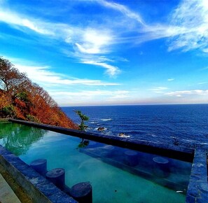 Alberca al aire libre, sombrillas en la alberca y camastros 