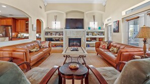 A spacious living room with leather sofas, a fireplace, and a television. - Perfect home for multiple families with beach tram service and a huge pool. (Inlet Beach, FL)