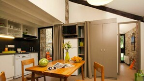 A compact kitchen with a dining table, chairs, and a refrigerator. - Beautiful apartment for 5 guests with WIFI, pool, TV, terrace and pets allowed (Les Vans)