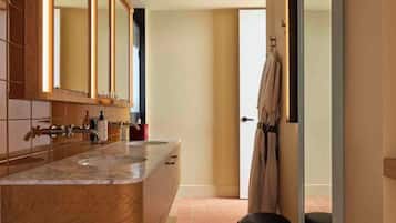 A modern bathroom with a wooden vanity, a large mirror, and a towel rack.
