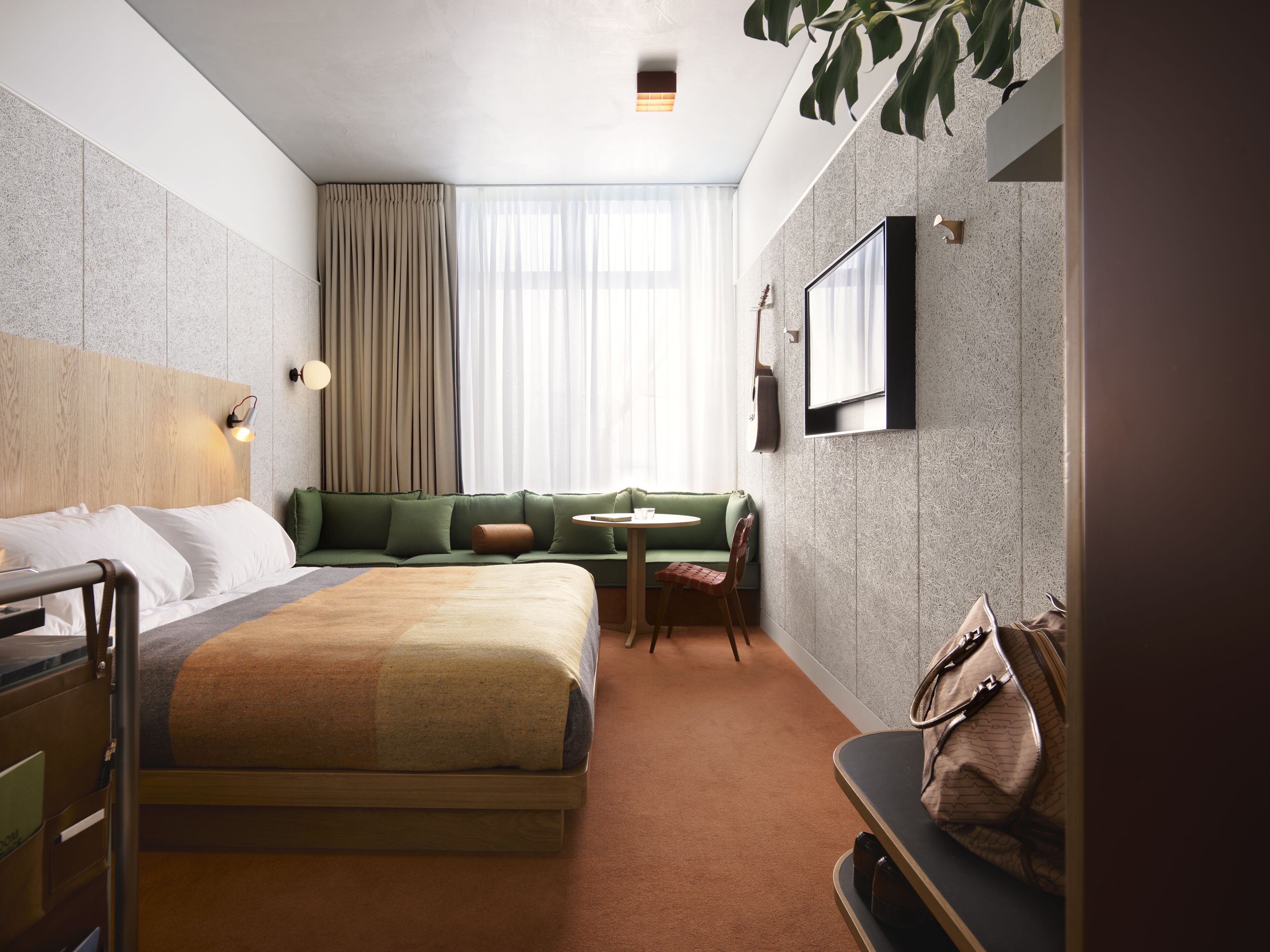 Une chambre d’hôtel avec un lit, un canapé, une petite table et une chaise.