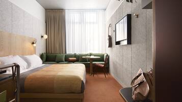 Une chambre d’hôtel avec un lit, un canapé, une petite table et une chaise.