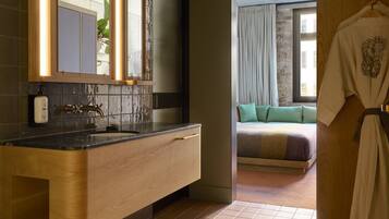A modern bathroom with a wooden vanity, a large mirror, and a sink.