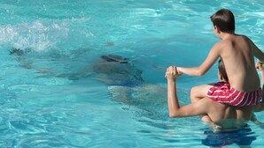 Eine Person in einem Swimmingpool mit klarem, blauem Wasser.