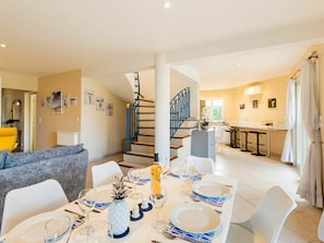 A modern living room with a dining area set for six, a staircase, and a kitchen in the background. - Beautiful private villa for 8 people with private pool, A/C, WIFI, TV and terrace (Saint-cyr-sur-mer)